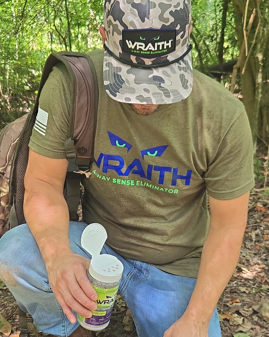 In the field: a kneeling hunter holding the WRAITH 16 oz shaker with its flip lid open