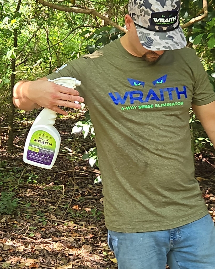 In the field: a hunter spraying downward with the WRAITH 23 oz spray bottle