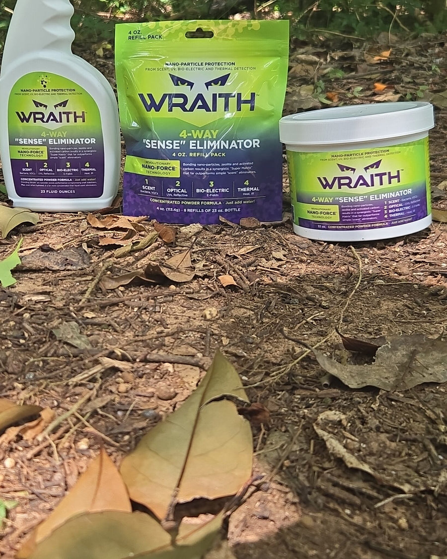 In the field: the WRAITH 32 oz bulk canister on the forest floor beside the spray bottle and 4 oz refill pack