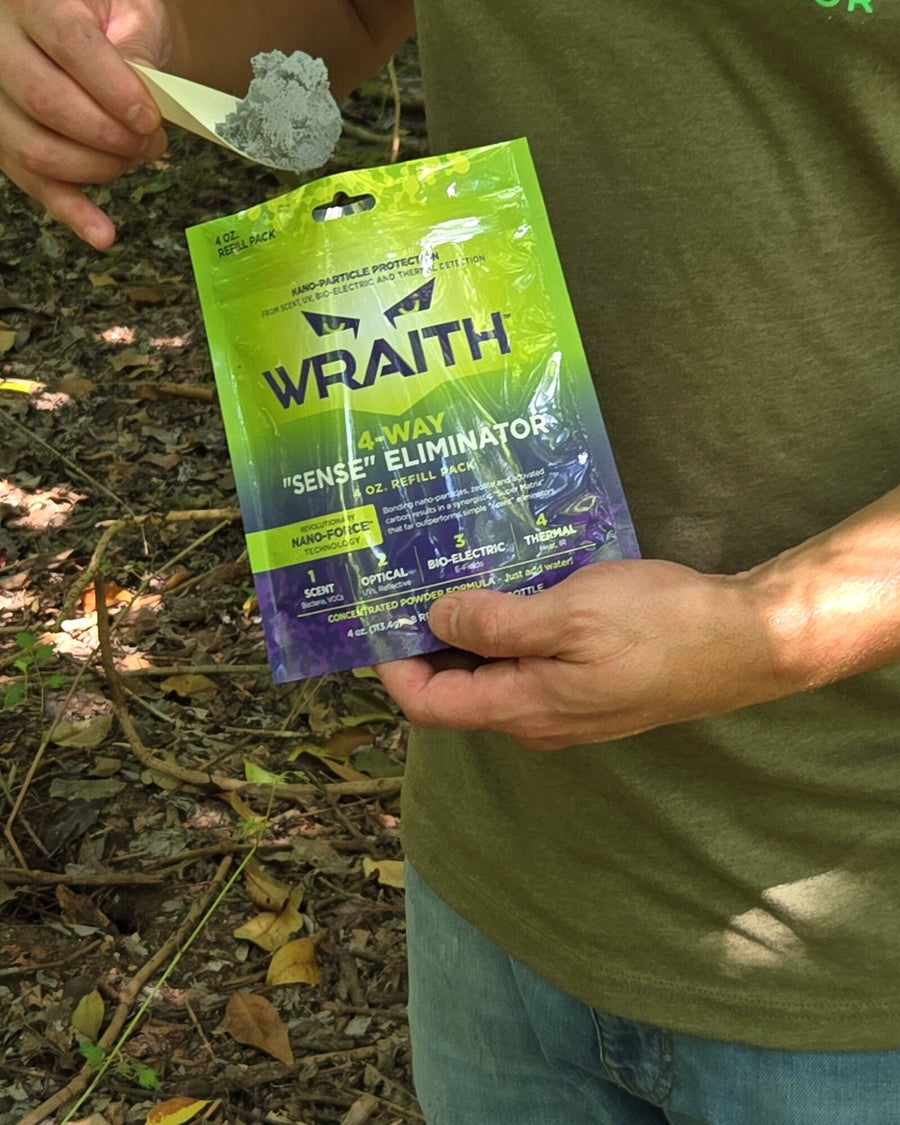 In the field: a hunter's hands holding the WRAITH 4 oz refill pouch open with the measuring scoop