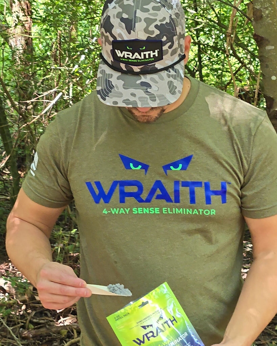 In the field: a hunter holding a scoop of WRAITH powder over the 4 oz refill pouch