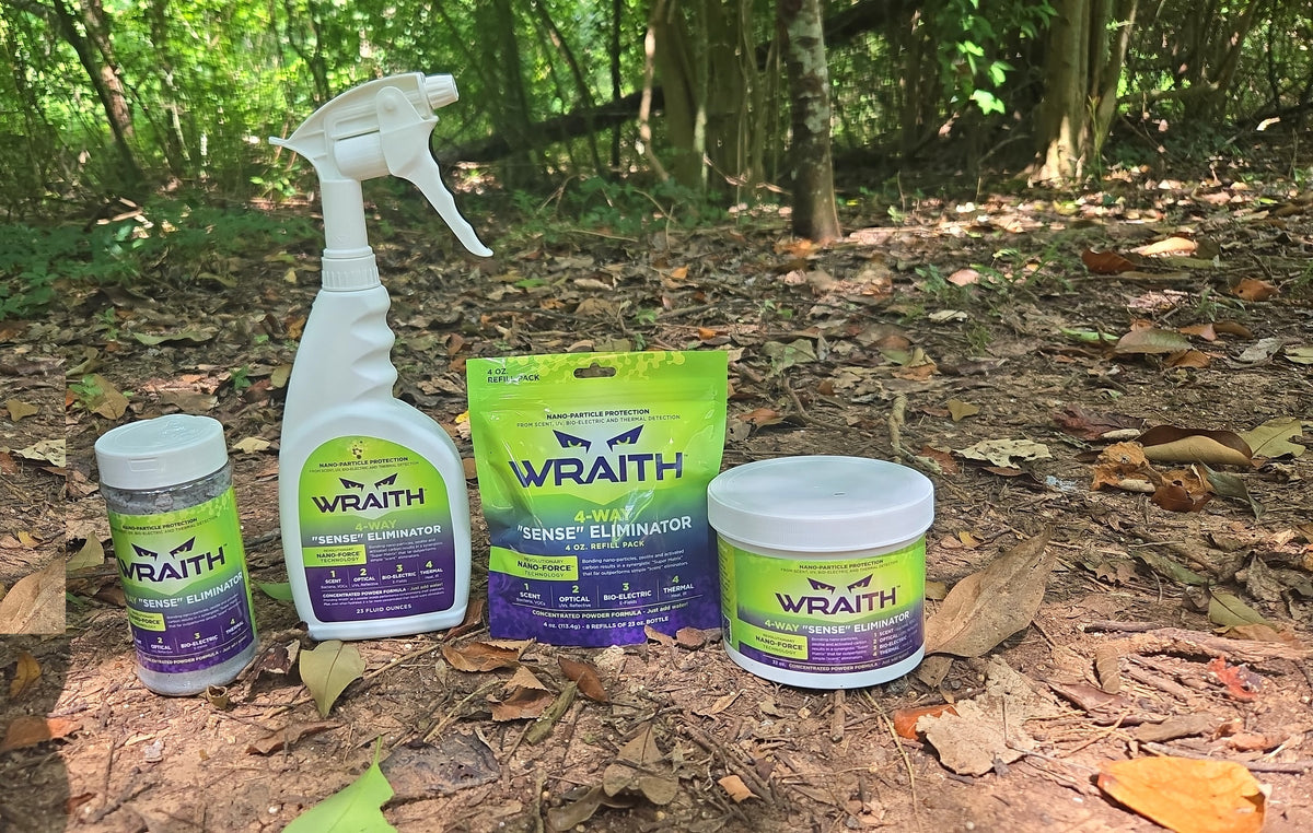 All four WRAITH package sizes side by side on the forest floor at true relative size: 16 oz shaker, 23 oz spray bottle, 4 oz refill pouch and 32 oz bulk canister